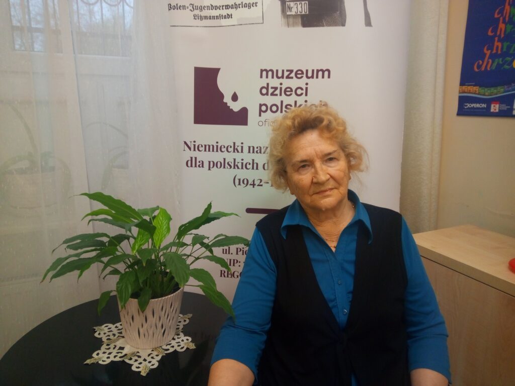 Współczesne zdjęcie. Kobieta siedzi przy stole.