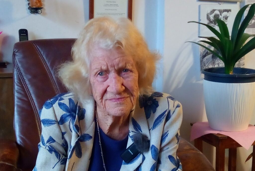 Współczesne zdjęcie. Kobieta siedzi w fotelu.